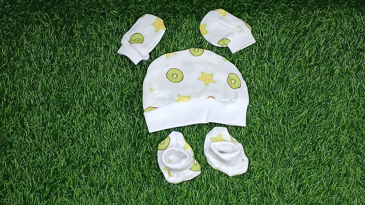 Set of baby clothes on a green grass background