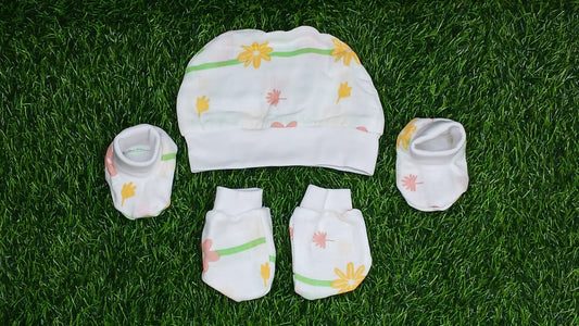 Baby clothing set including a hat, socks, and pants on grass