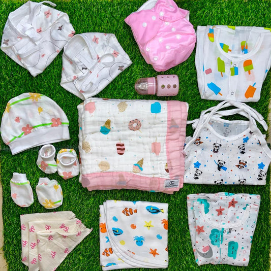 Collection of baby clothes and items on a green grass-like surface